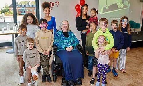 Picture of Professor Jean Golding sitting surrounded by children and parents from the Children of the 90's study.